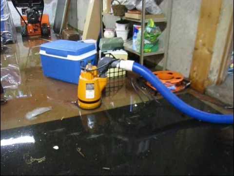Pump removing water from a flooded basement